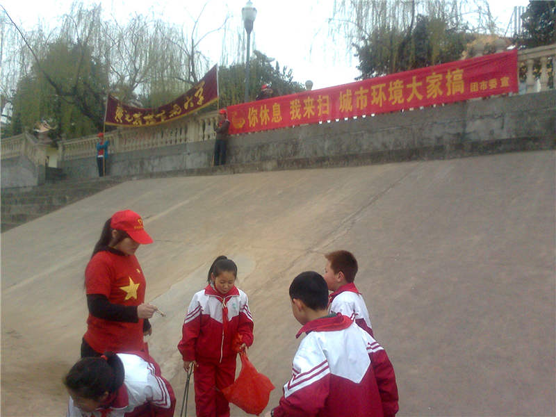 我校青年志愿者和实验小学的小朋友们一起劳动中